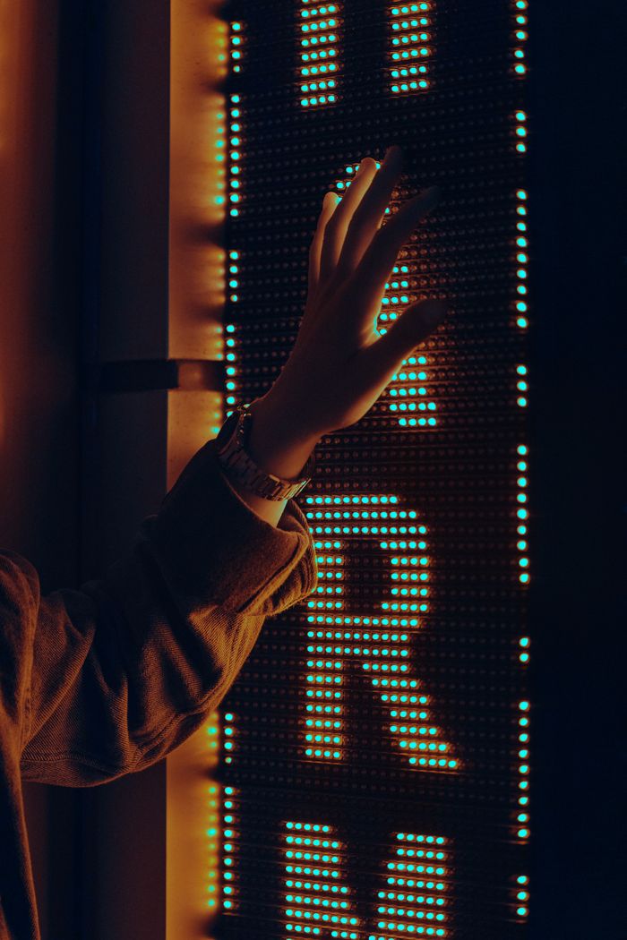 Crafting Captivating Headlines: Your awesome post title goes here A hand reaching towards a brightly lit neon sign in the dark with a warm glow.